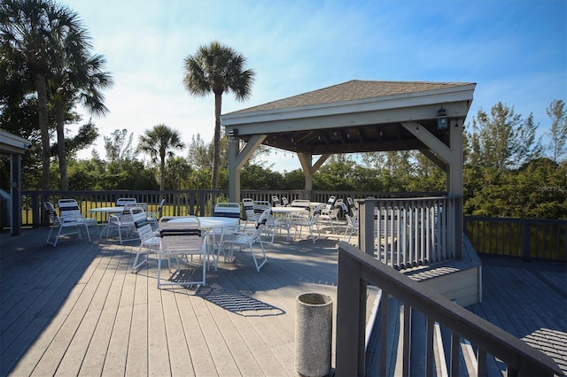 wooden terrace with outdoor dining space and a gazebo