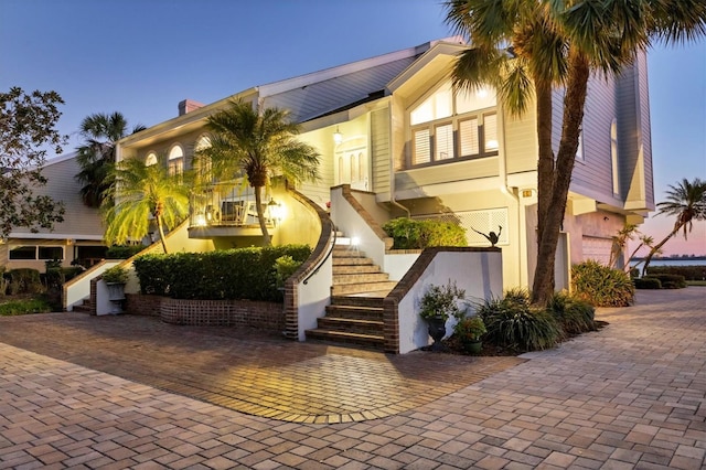 view of front facade featuring decorative driveway and stairway