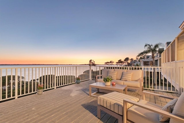 deck at dusk with a water view and an outdoor hangout area