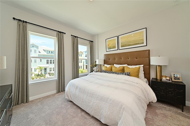 bedroom with baseboards and light colored carpet