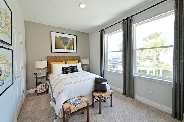 bedroom featuring light colored carpet and baseboards