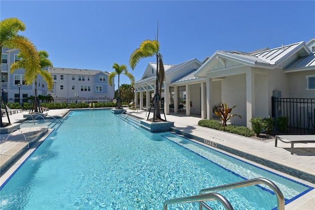 pool with a residential view, a patio area, and fence