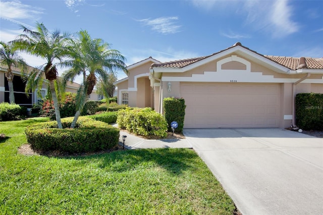 mediterranean / spanish home featuring a garage, driveway, a tiled roof, and stucco siding