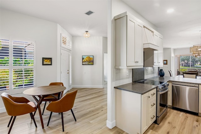 kitchen with light wood-style floors, tasteful backsplash, visible vents, and stainless steel appliances