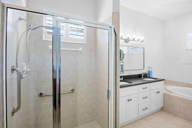 bathroom with a garden tub, a shower stall, vanity, and tile patterned floors