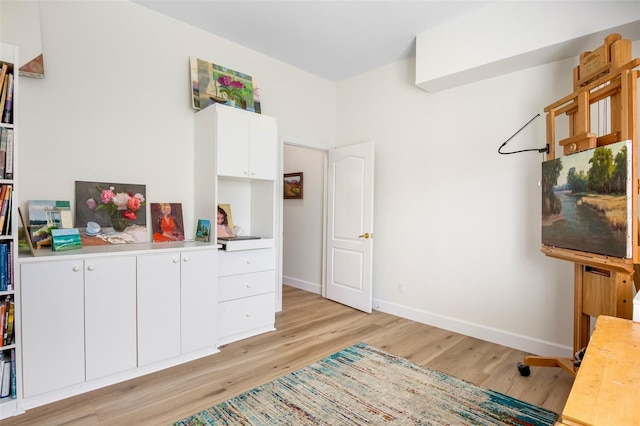 office space with light wood-type flooring and baseboards