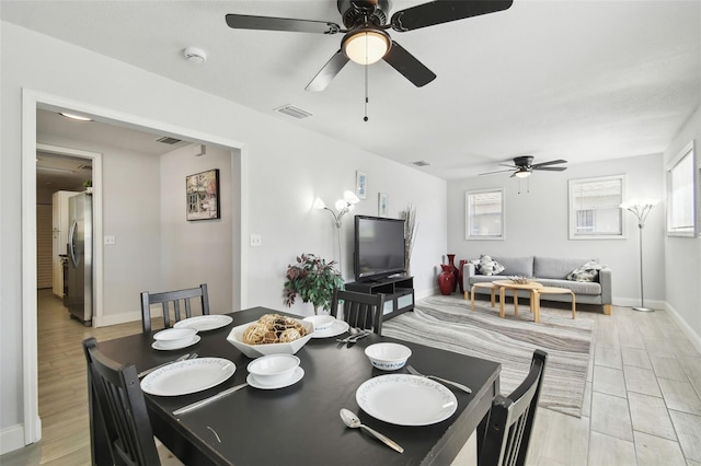 dining space with a ceiling fan, visible vents, and baseboards