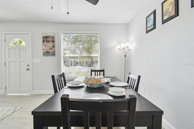 dining space with wood finished floors, a ceiling fan, and baseboards