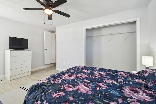 bedroom with a closet, wood finished floors, a ceiling fan, and baseboards