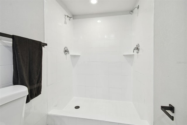 full bath featuring a tile shower and toilet