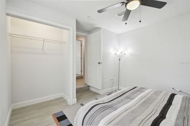 bedroom featuring light wood-style flooring, visible vents, baseboards, and a ceiling fan