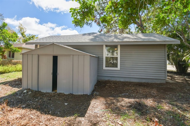 back of house featuring a storage shed, board and batten siding, and an outdoor structure