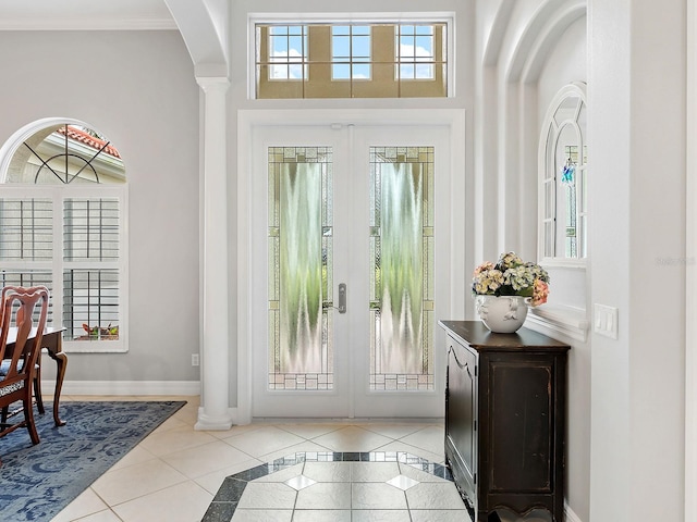 tiled entryway with ornamental molding, french doors, plenty of natural light, and baseboards