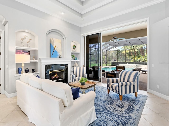 living area with built in features, light tile patterned floors, a premium fireplace, a sunroom, and baseboards