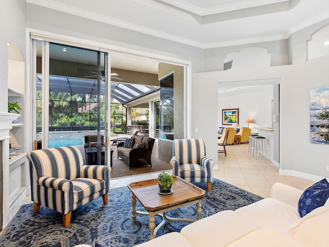 living room with light tile patterned floors, a sunroom, baseboards, ornamental molding, and a tray ceiling