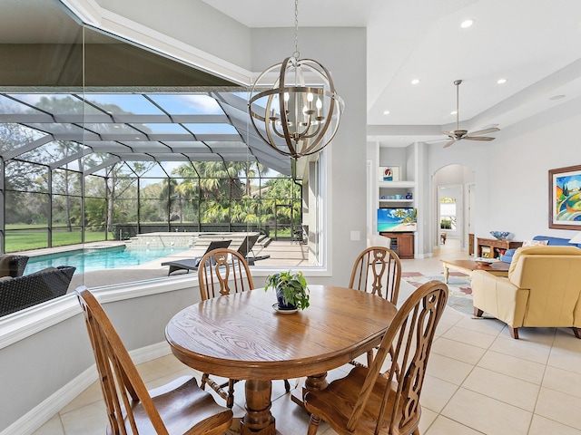 dining room with light tile patterned floors, baseboards, arched walkways, a sunroom, and recessed lighting