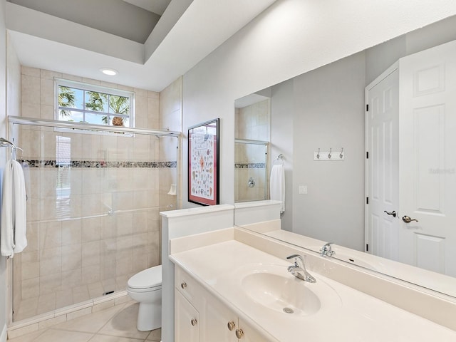 bathroom with a stall shower, vanity, toilet, and tile patterned floors