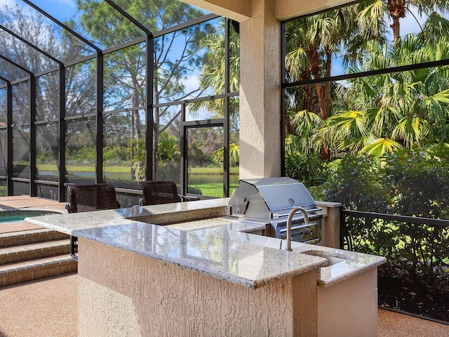 view of patio with outdoor dry bar, exterior kitchen, area for grilling, and a lanai