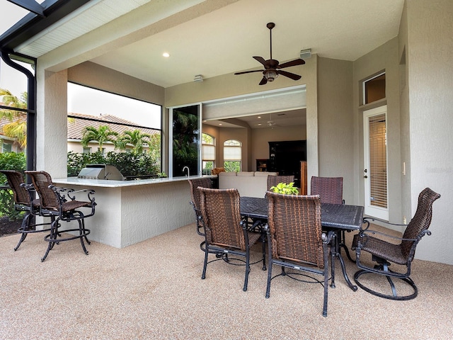 view of patio / terrace featuring ceiling fan, exterior kitchen, outdoor dining area, and outdoor wet bar