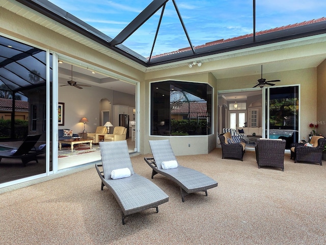 view of patio / terrace with glass enclosure, an outdoor living space, and a ceiling fan