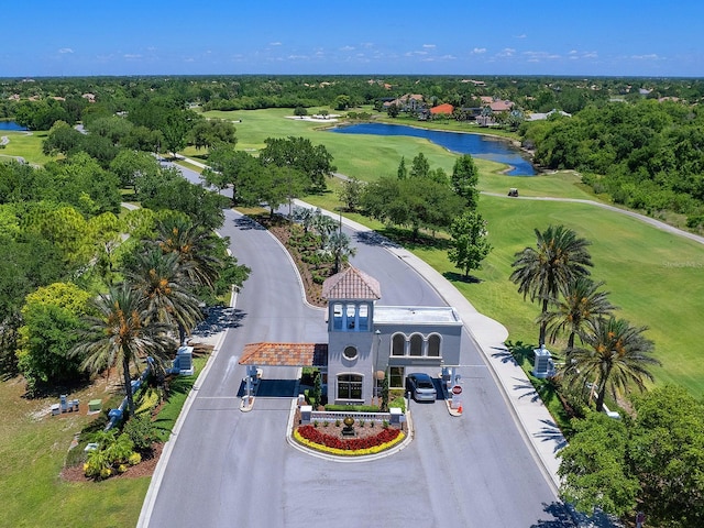 drone / aerial view featuring golf course view and a water view