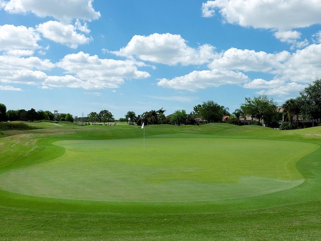 view of home's community featuring golf course view and a lawn