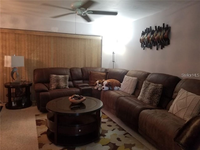 living room featuring light carpet, ceiling fan, and wooden walls