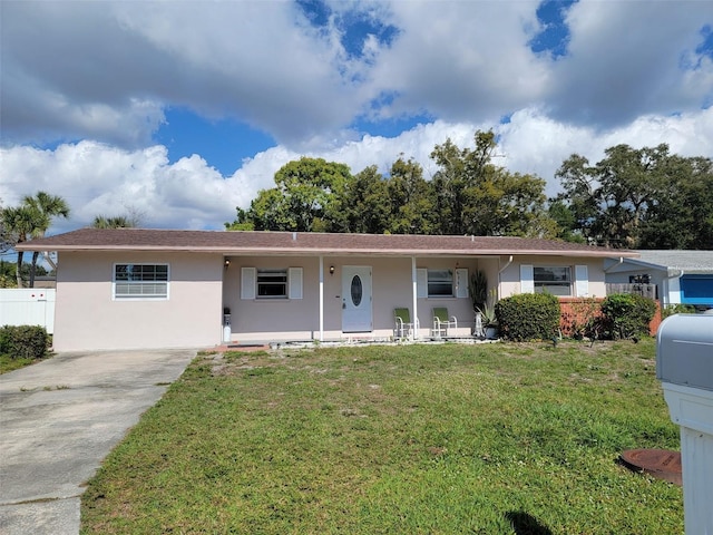 ranch-style home featuring stucco siding, a porch, concrete driveway, and a front yard