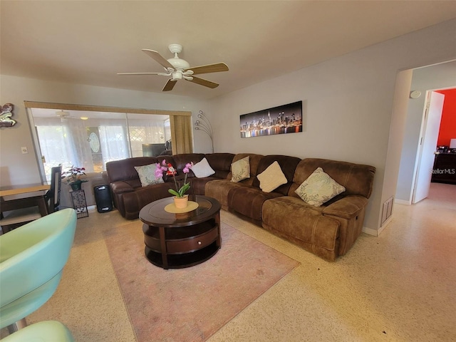 living area featuring visible vents, speckled floor, and ceiling fan