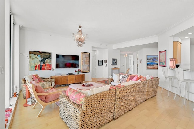 living room with ornamental molding, light wood-style flooring, and an inviting chandelier