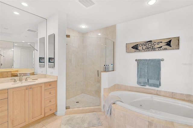 full bath featuring a stall shower, tile patterned flooring, vanity, and a whirlpool tub