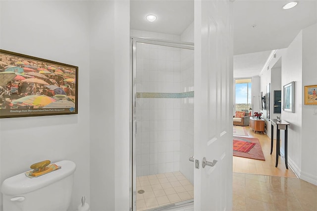 full bathroom featuring a shower stall, toilet, and baseboards