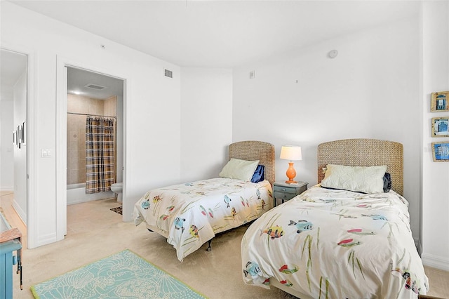 carpeted bedroom featuring connected bathroom and visible vents