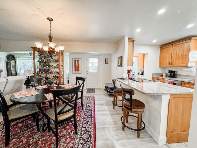 dining space with a healthy amount of sunlight, light wood-style flooring, a chandelier, and recessed lighting