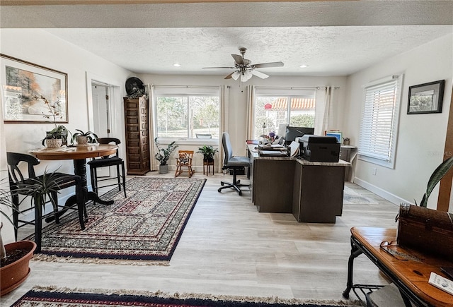 office space with a healthy amount of sunlight, light wood-style floors, and a textured ceiling