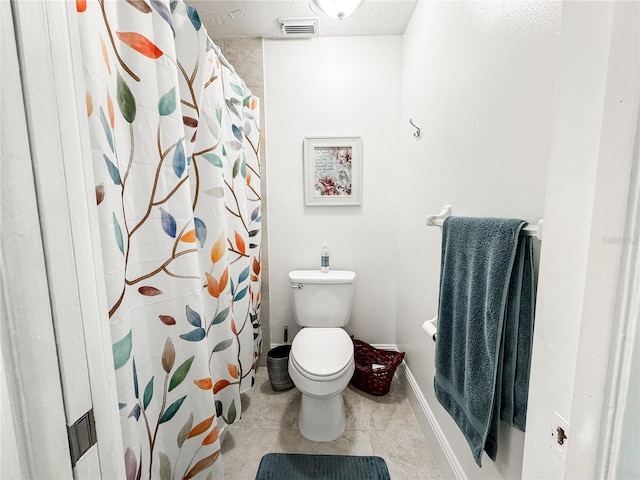 bathroom with toilet, tile patterned floors, visible vents, baseboards, and a shower with curtain