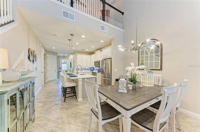 11607 Meadowgate Pl, Bradenton, FL 34211 - dining room featuring baseboards, visible vents, a towering ceiling, and a chandelier