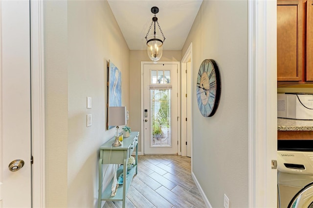 11607 Meadowgate Pl, Bradenton, FL 34211 - entryway featuring wood finish floors, baseboards, and washer / dryer