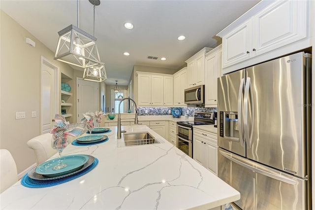 11607 Meadowgate Pl, Bradenton, FL 34211 - kitchen with a sink, visible vents, appliances with stainless steel finishes, and white cabinetry