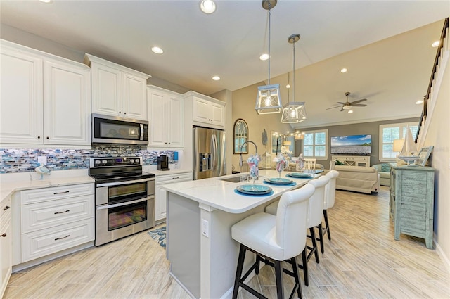 11607 Meadowgate Pl, Bradenton, FL 34211 - kitchen with backsplash, open floor plan, appliances with stainless steel finishes, white cabinetry, and a sink