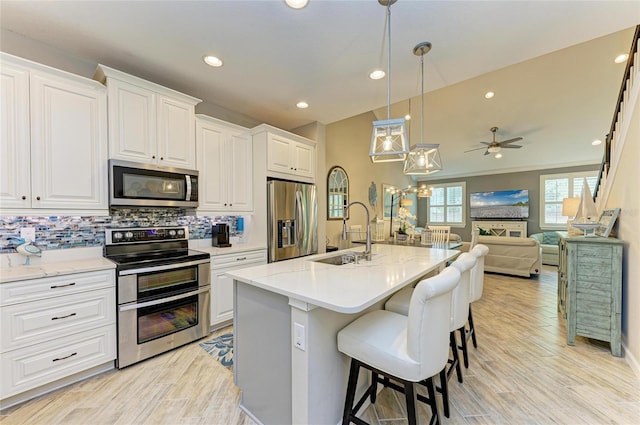 11607 Meadowgate Pl, Bradenton, FL 34211 - kitchen with a sink, decorative backsplash, stainless steel appliances, white cabinets, and open floor plan