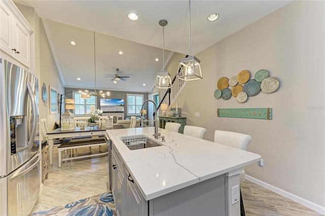 11607 Meadowgate Pl, Bradenton, FL 34211 - kitchen with a breakfast bar area, a ceiling fan, an island with sink, a sink, and stainless steel fridge