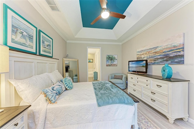 11607 Meadowgate Pl, Bradenton, FL 34211 - bedroom with a ceiling fan, visible vents, light wood-style flooring, ensuite bathroom, and a raised ceiling