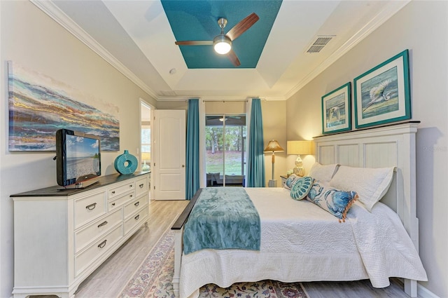 11607 Meadowgate Pl, Bradenton, FL 34211 - bedroom with a ceiling fan, visible vents, crown molding, a raised ceiling, and light wood-type flooring