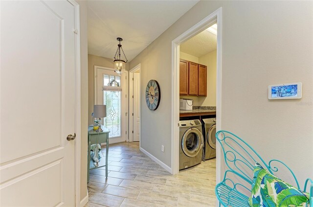 11607 Meadowgate Pl, Bradenton, FL 34211 - laundry area with baseboards, cabinet space, light wood-style floors, washer and dryer, and a chandelier