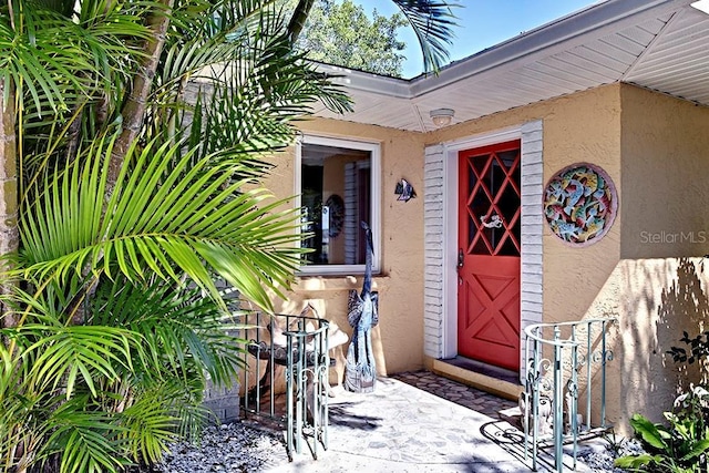 view of exterior entry featuring stucco siding