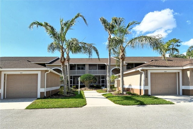 view of front of home with a garage, concrete driveway, and stucco siding