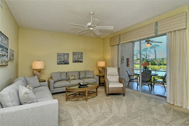 carpeted living room with a ceiling fan and a textured ceiling