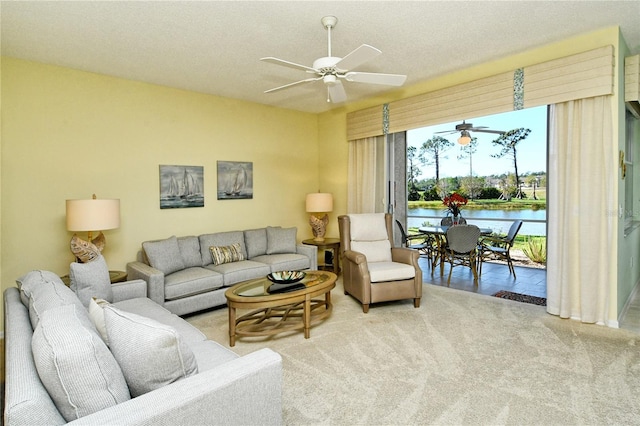 carpeted living room with ceiling fan and a textured ceiling