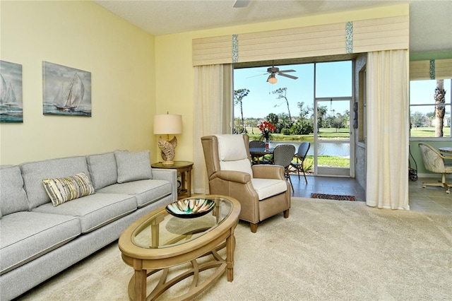 carpeted living room featuring a ceiling fan and a textured ceiling